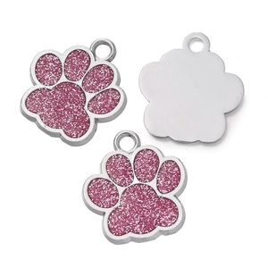 Détail de pendentifs en forme de pattes roses pailletées avec cadres en métal argenté