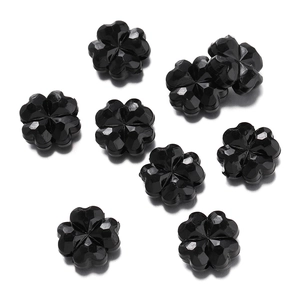 Vista superior de ocho cuentas de trébol en acrílico negro facetado para joyería DIY