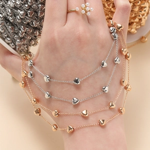 Pulsera artesanal de cobre con dijes de corazón y cadena fina bañada en oro