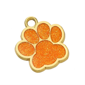 Détail d'un pendentif patte de chien dorée avec paillettes orange pour bijoux DIY