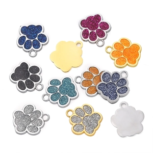 Vue macro de breloques patte de chien à paillettes colorées avec dos en métal poli