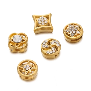 Detailed view of gold stainless steel spacer beads with sparkling crystal inlay designs