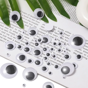 Close-up of various sized self-adhesive googly eyes for creative DIY craft doll making