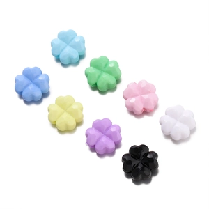 Detalle de cuentas de trébol en acrílico colorido para creación de joyas DIY
