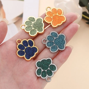 Gros plan de pendentifs en forme de patte de chien pailletés en cinq couleurs variées