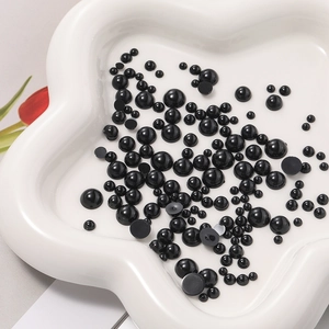 Dettaglio di occhi neri lucidi in resina per bambole fai-da-te in un piatto di ceramica