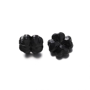 Detalle macro de cuentas de trébol negro de cuatro hojas con corte facetado para DIY