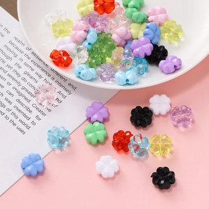 Detalle de cuentas de trébol de acrílico coloridas para la creación de joyas hechas a mano