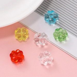Primer plano de cuentas de trébol de acrílico facetado de colores para joyería artesanal
