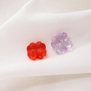 Vista macro detallada de cuentas de trébol facetadas rojas y moradas para joyería DIY
