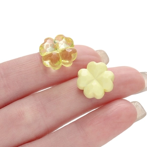 Primer plano de cuentas de trébol de acrílico amarillo facetado para joyería DIY
