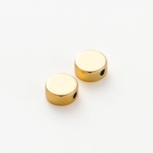 Detailed view of 14K gold plated flat round spacer beads with mirror finish and side holes