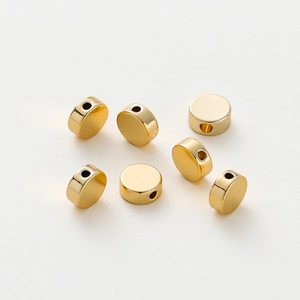 Macro detail of seven flat 18K gold-plated spacer beads for DIY jewelry making