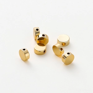 Close-up of polished 14K gold plated flat round beads for DIY jewelry making