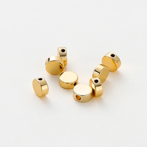 Close-up of polished 18K gold plated flat round spacer beads for DIY jewelry making