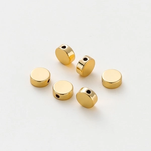 Close-up of 14K gold plated flat round spacer beads with holes for DIY jewelry making