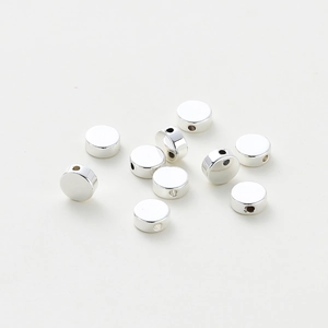 Macro detail of 10 silver plated flat round spacer beads with polished surface for DIY jewelry