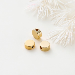 Polished 14K gold plated flat round beads for jewelry making shown in a set of three