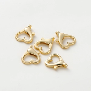 Dettaglio di cinque moschettoni dorati a forma di cuore per accessori fai da te gioielli