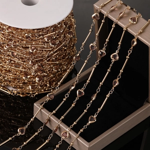Détail de la chaîne à cœurs et perles or rose sur bobine pour bijoux DIY