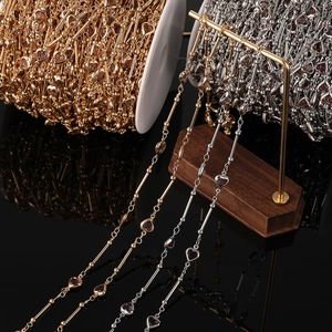 Détail d'une chaîne bijoux DIY avec cristaux en forme de cœur dorés et argentés