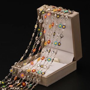 Detailed macro view of colorful enamel daisy chains with faceted crystals on metal link jewelry