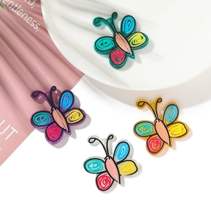Close-up of colorful butterfly charms in purple, blue and yellow for DIY jewelry making