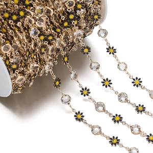 Detail of daisy flower chain with yellow crystals on white spool for DIY accessories
