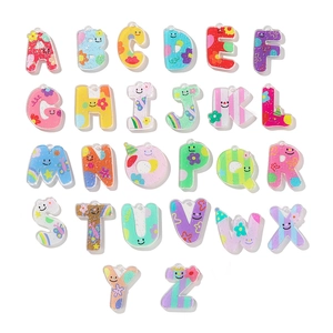 Gros plan de pendentifs alphabet A-Z en acrylique coloré avec motifs floraux et sourires
