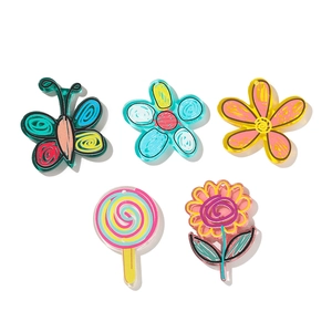 Flat lay of colorful acrylic flower and butterfly charms for DIY cream glue crafts