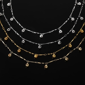 Détail de chaînes à clochettes en or et argent sur miroir noir pour bijoux DIY