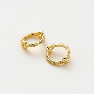 Detalle de anillos de cuentas con doble agujero bañados en oro con textura de cuerda torcida