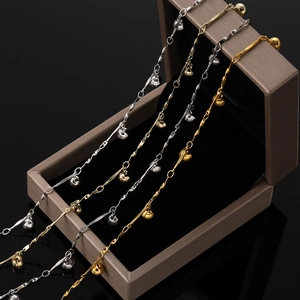 Détail de chaînes à maillons de cœur or et argent avec clochettes sur un coffret