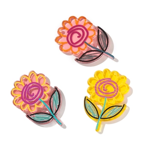 Close-up of translucent acrylic flower charms with hand-drawn graffiti style for DIY crafts
