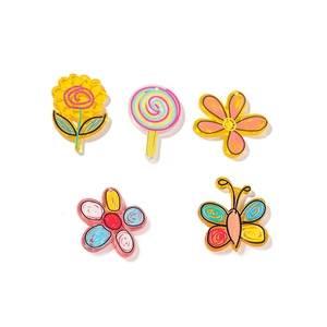 Close-up of colorful acrylic floral and butterfly charms for DIY craft decoration