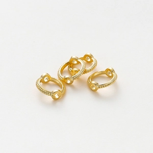 Vista macro de conectores redondos de cuerda trenzada bañados en oro de 14K para joyería DIY