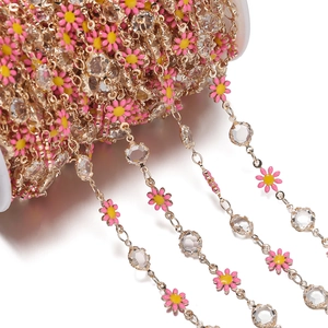 Detail of DIY jewelry chain with pink and yellow daisies and clear faceted crystals