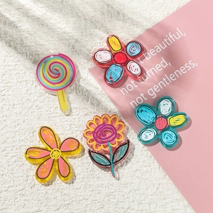 Detail of DIY acrylic floral and rainbow lollipop charms with hand-painted patterns