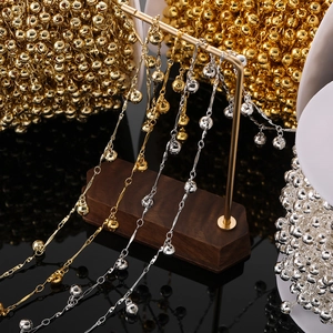 Gros plan de chaînes à clochettes dorées et argentées sur un support pour bijoux DIY