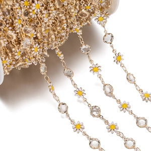 Detailed view of daisy and crystal gold chain on spool for DIY jewelry making