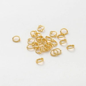 Detalle macro de anillos de cuentas texturizados bañados en oro de 14K para accesorios DIY