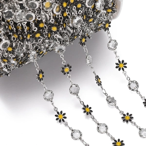 Detailed view of silver daisy chain with black enamel flowers and sparkling crystals