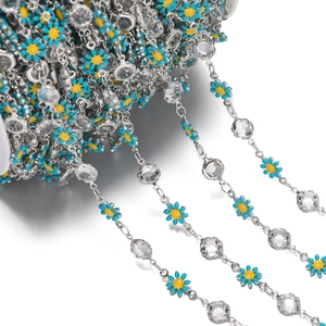 Detailed view of silver daisy chain with blue enamel flowers and clear faceted crystals