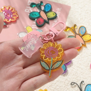 Detail of sweet floral acrylic keychain with yellow flower and pink candy charms
