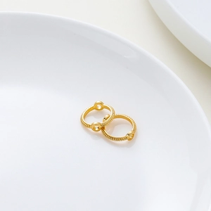 Detalle macro de anillos de cuentas texturizados en oro 18K para joyería DIY