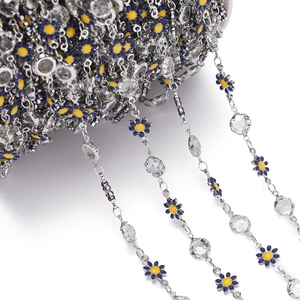 Detail view of blue daisy enamel charms and faceted crystal beads on a silver DIY chain