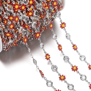 Detailed view of red enamel daisy chain with crystals on a white spool for DIY jewelry