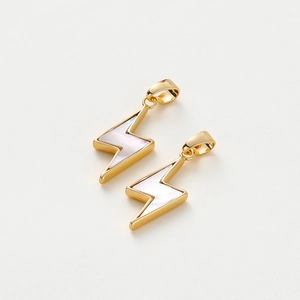 Macro detail of 18K gold lightning shell charms with iridescent mother of pearl insets