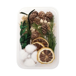 Detailed close-up of DIY dried flower set with pine cones and cinnamon in a clear box