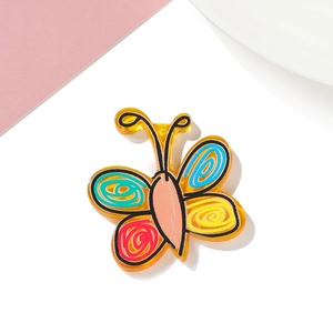 Detailed macro of yellow acrylic butterfly charm with colorful hand-painted spiral patterns